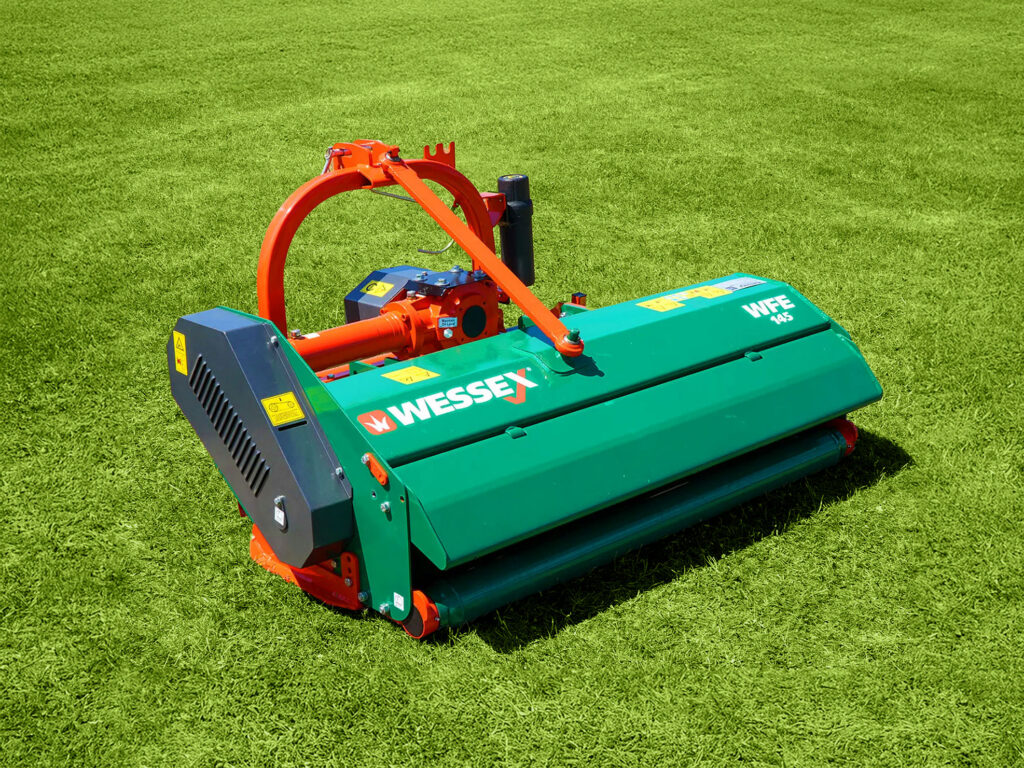 A flail mower sitting on green grass